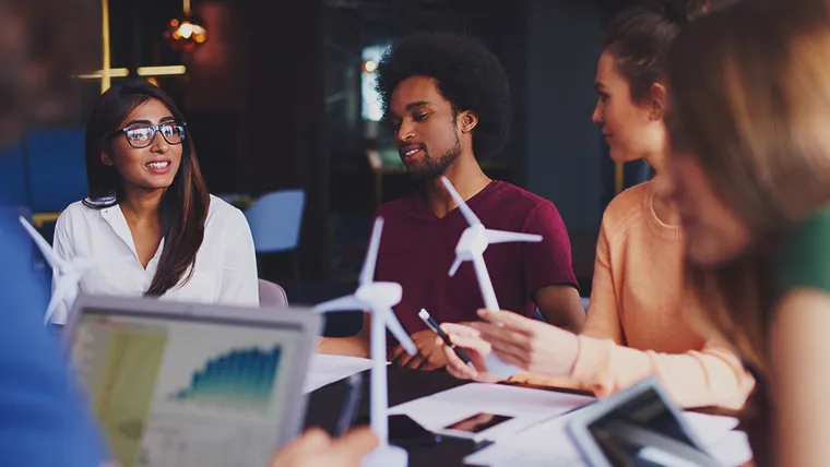 employees around table discussing sustainable businesses